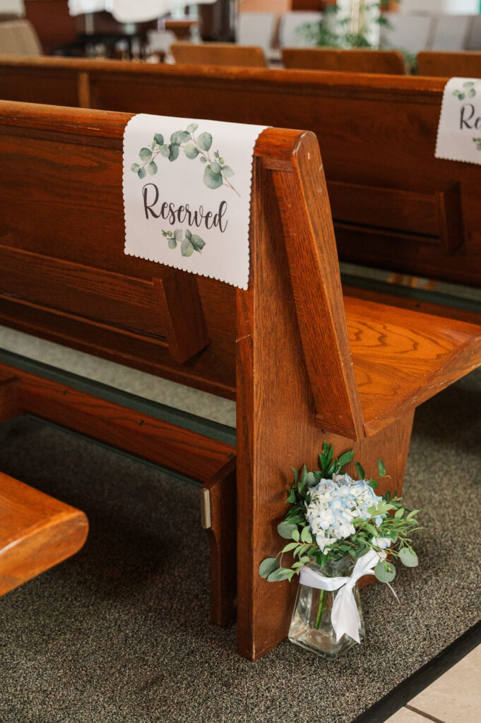 decorated wedding pew in catholic church