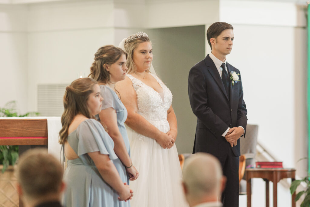 bride and groom with bridesmaids during ceremony
