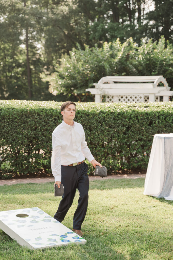 groom playing corn hole