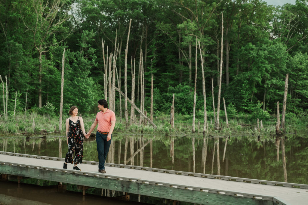 Chelsea and Alex walking hand-in-hand along the boardwalk during their Huntley Meadows engagement session in Northern Virginia.