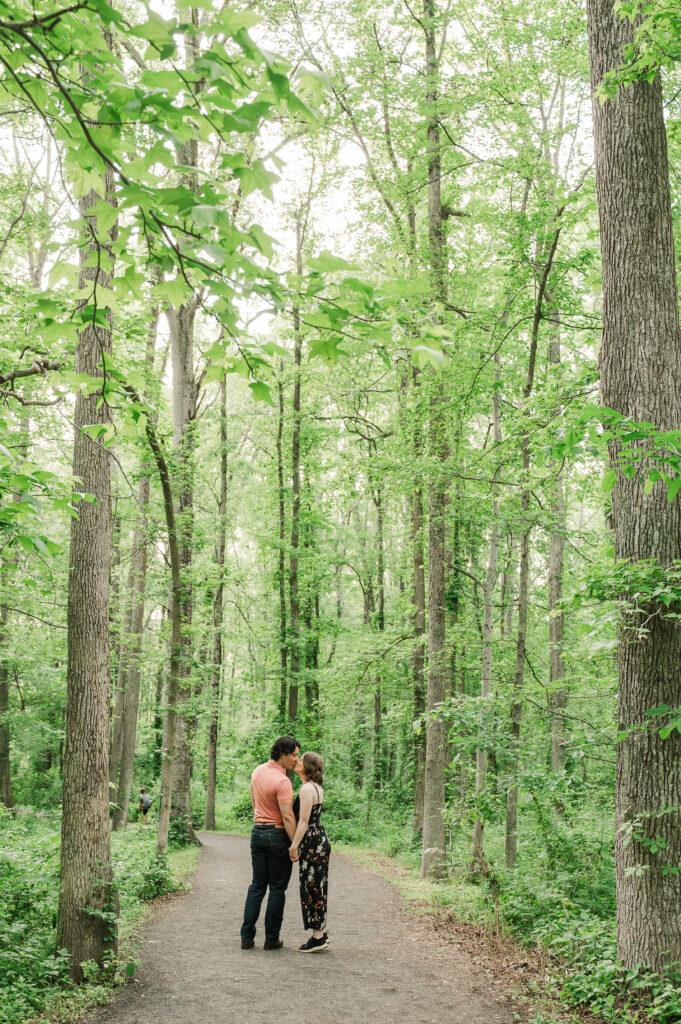 Candid moment of the couple smiling and walking on the trail during their Virginia nature engagement session.