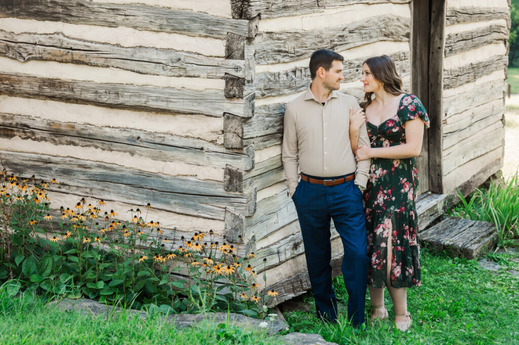 couple standing beside log cabin