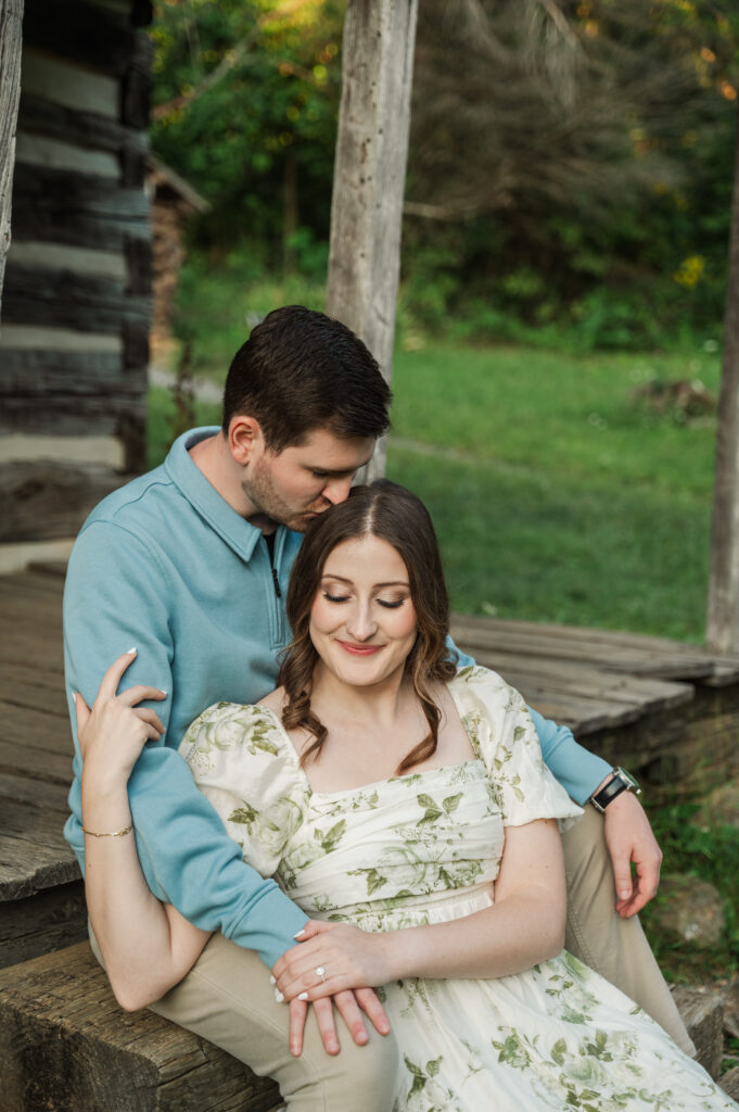 couple sitting on log cabin porch