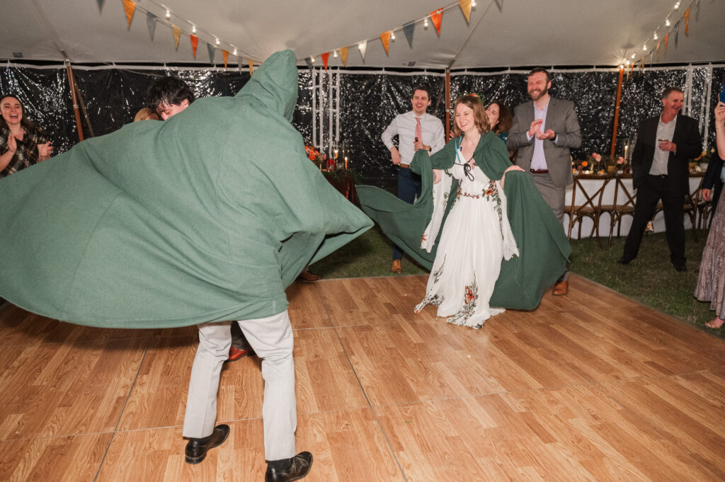 bride and groom wearing capes during reception