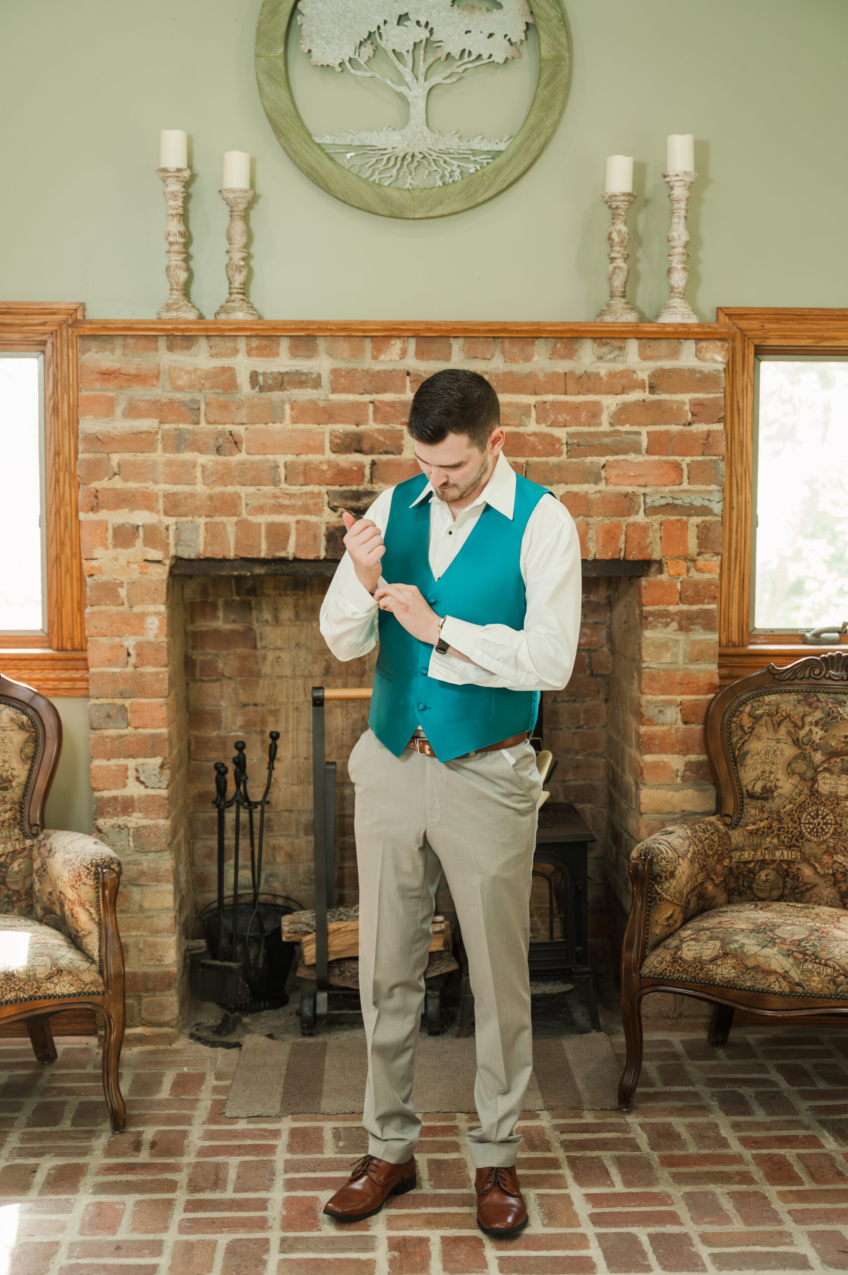 Groom Devin adding cufflinks to his shirt before the ceremony.