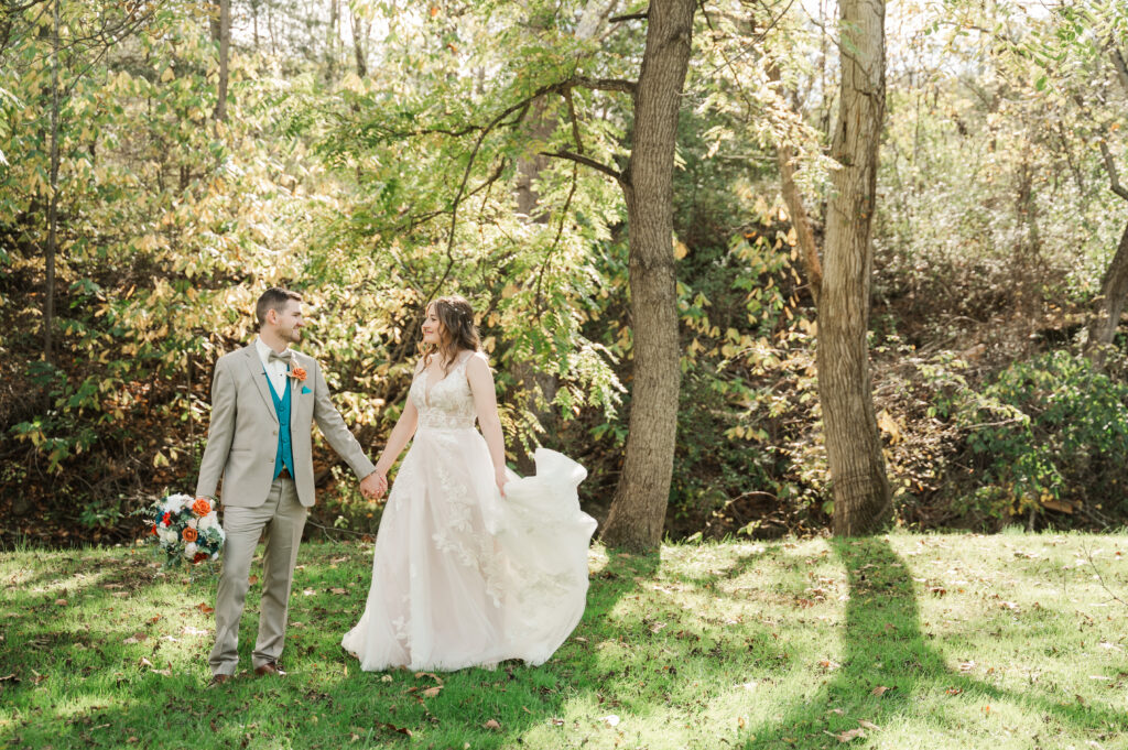 Bride and groom laughing together  near the water.