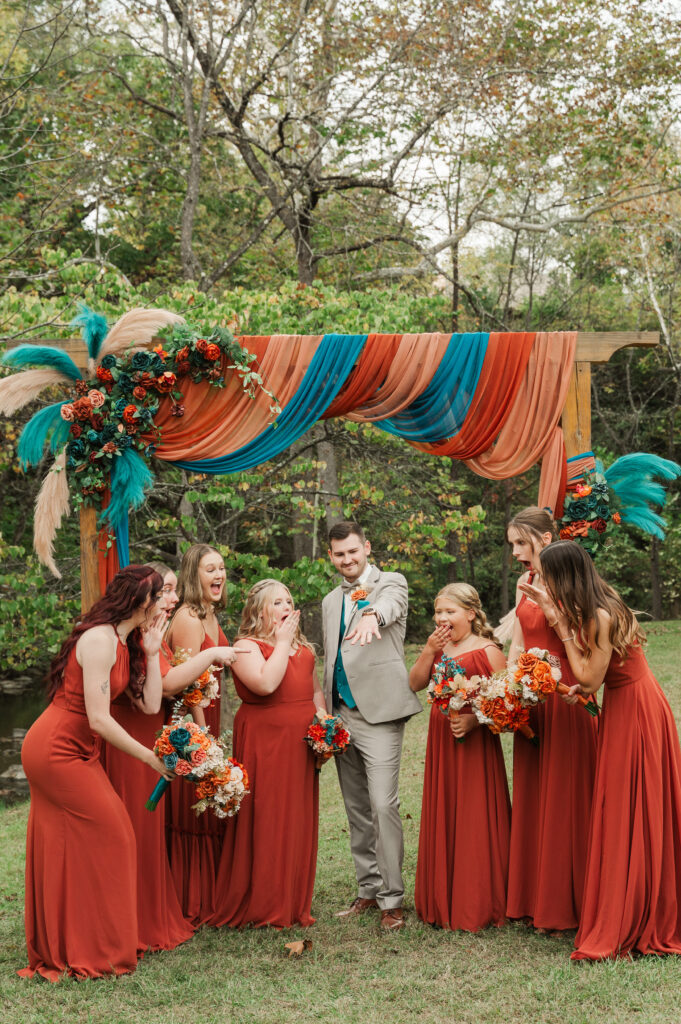 groom showing off his ring to bridesmaids