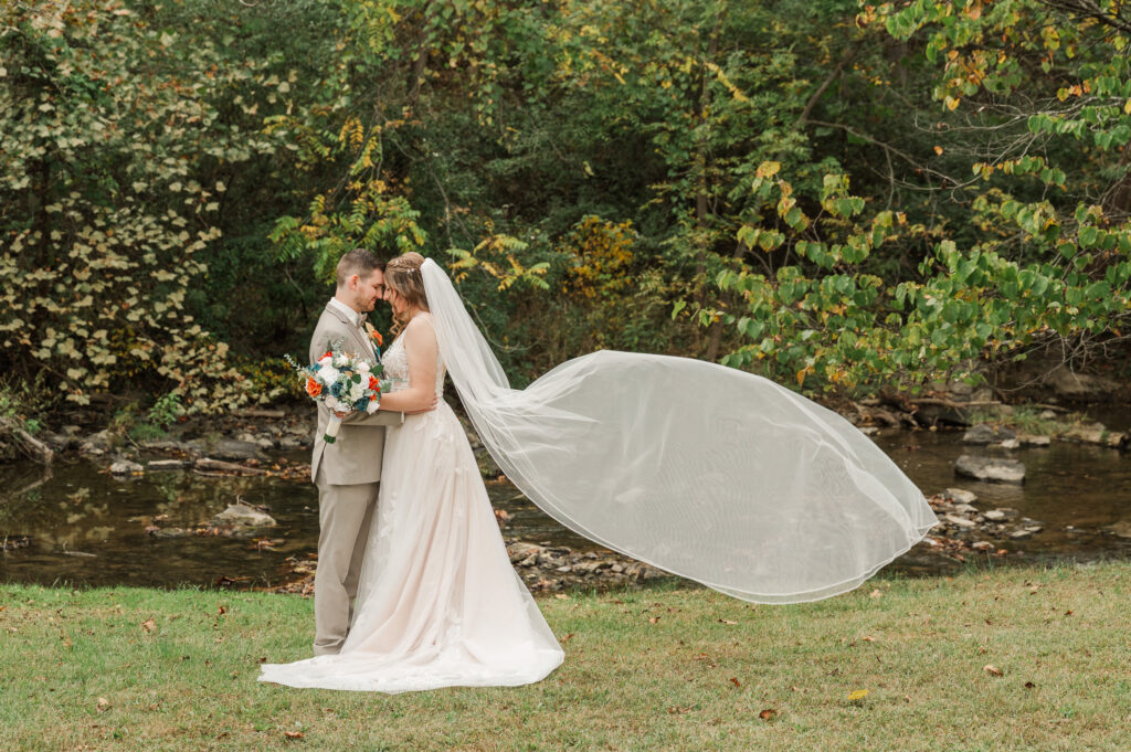 Romantic bride and groom portraits by the river at Valley Mills Farm.