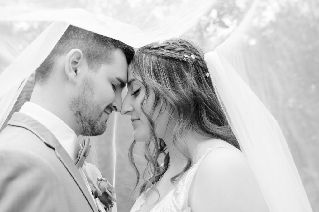 Groom holding the bride close under the veil