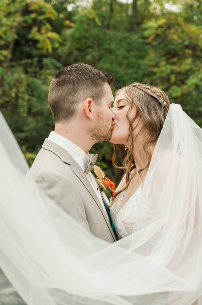 Close up of bride and groom kissing by the river