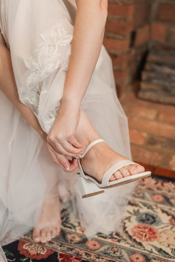 bride putting on wedding shoes