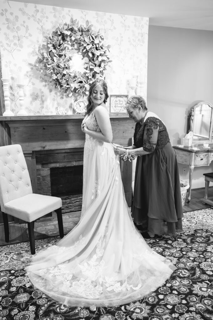 Mom zipping Bride McKenzi's dress
