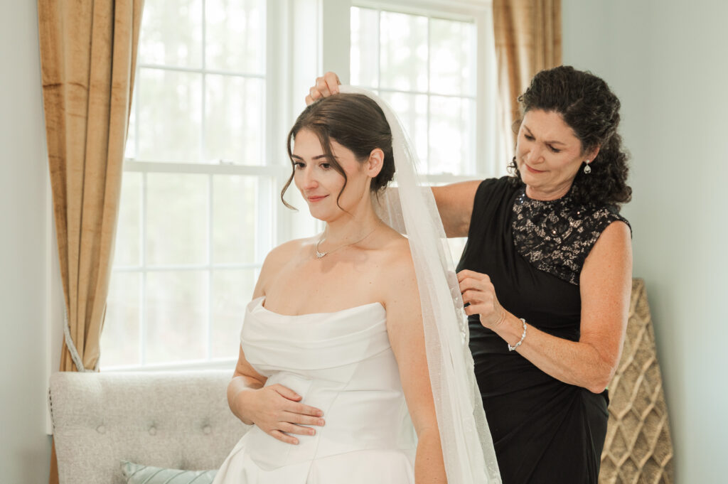 mother of bride putting on bride's veil