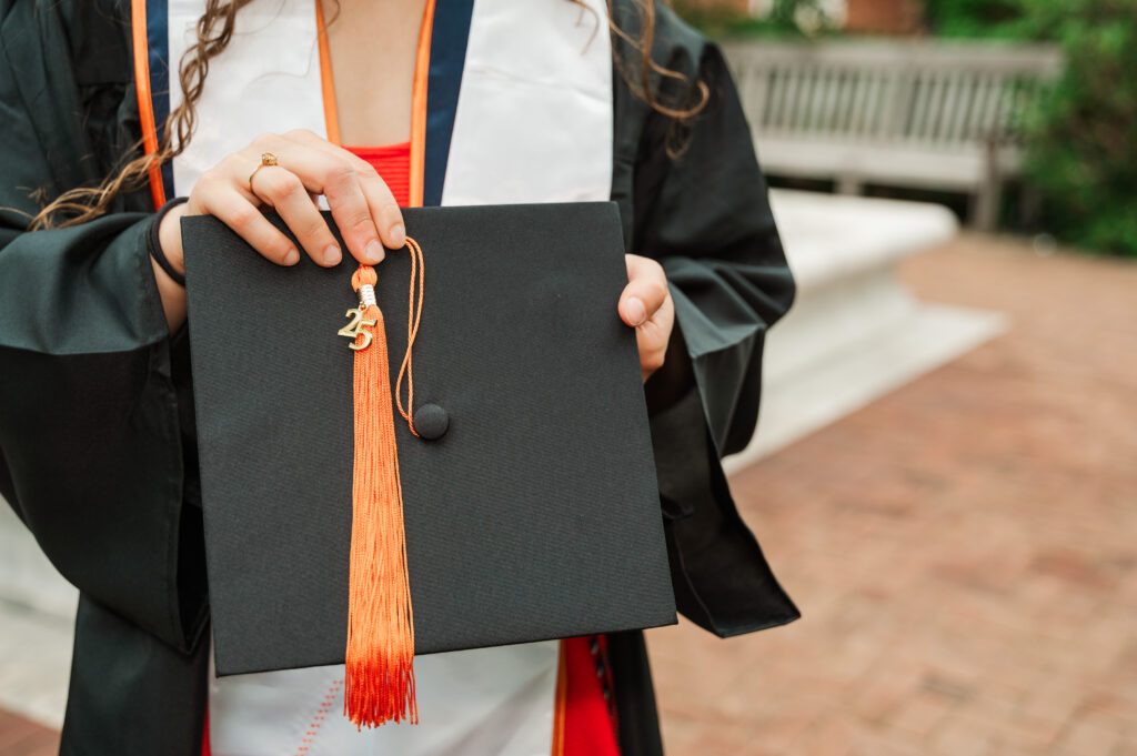 Emily holding her graduation cap with the 25 tassel