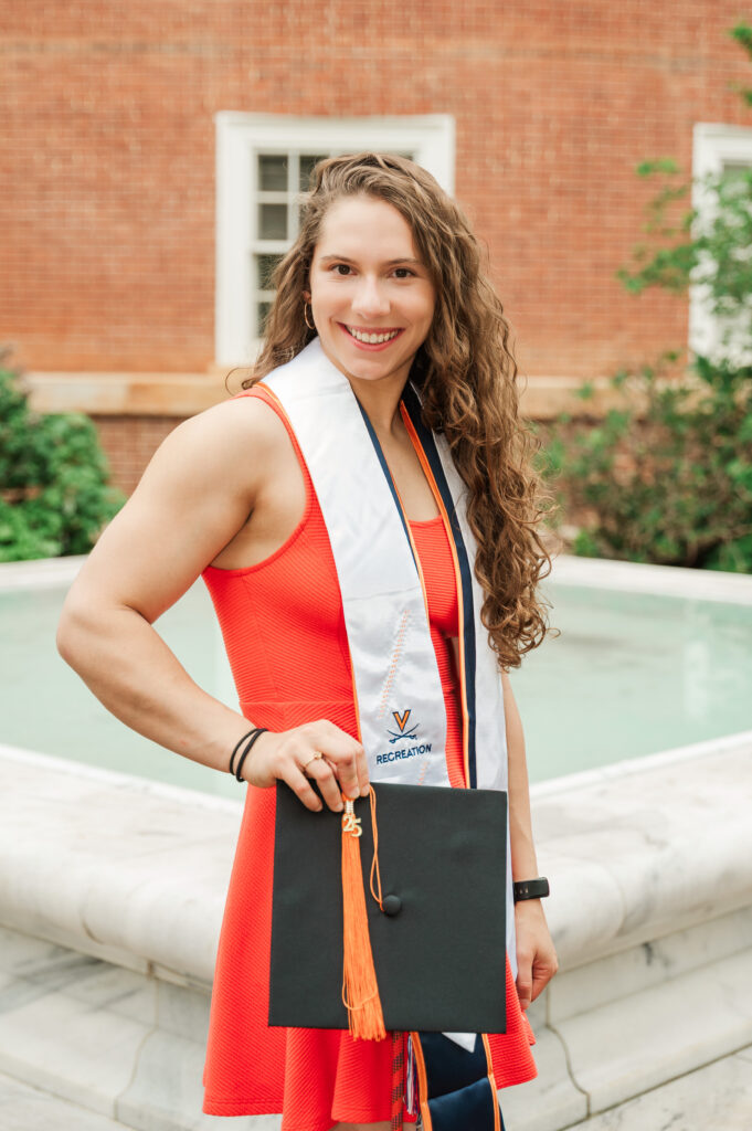Emily holding her graduation cap in the East Courtyard