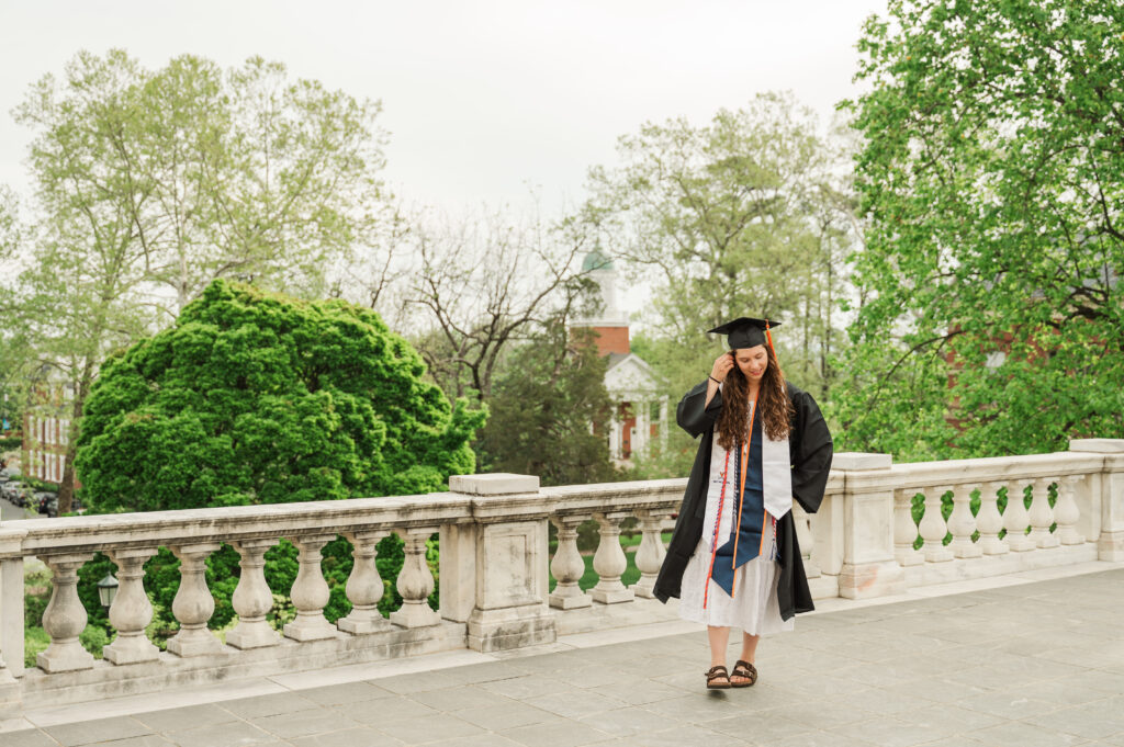 Emily walking on terrace in graduation cap and gown
