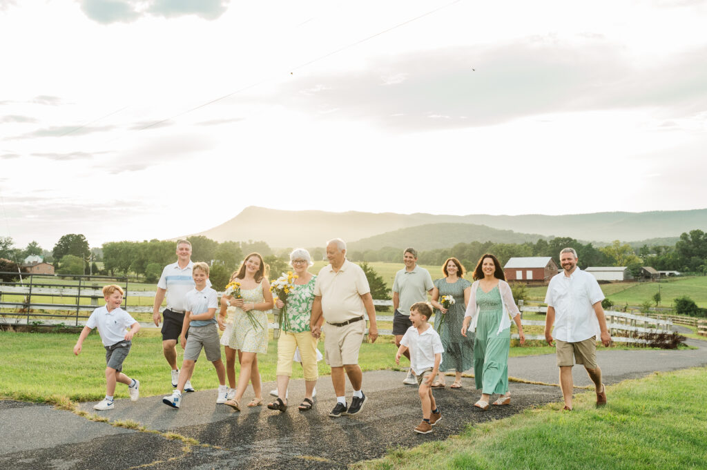 Extended family of three generations walking together toward the camera on a mountain property in Elkton