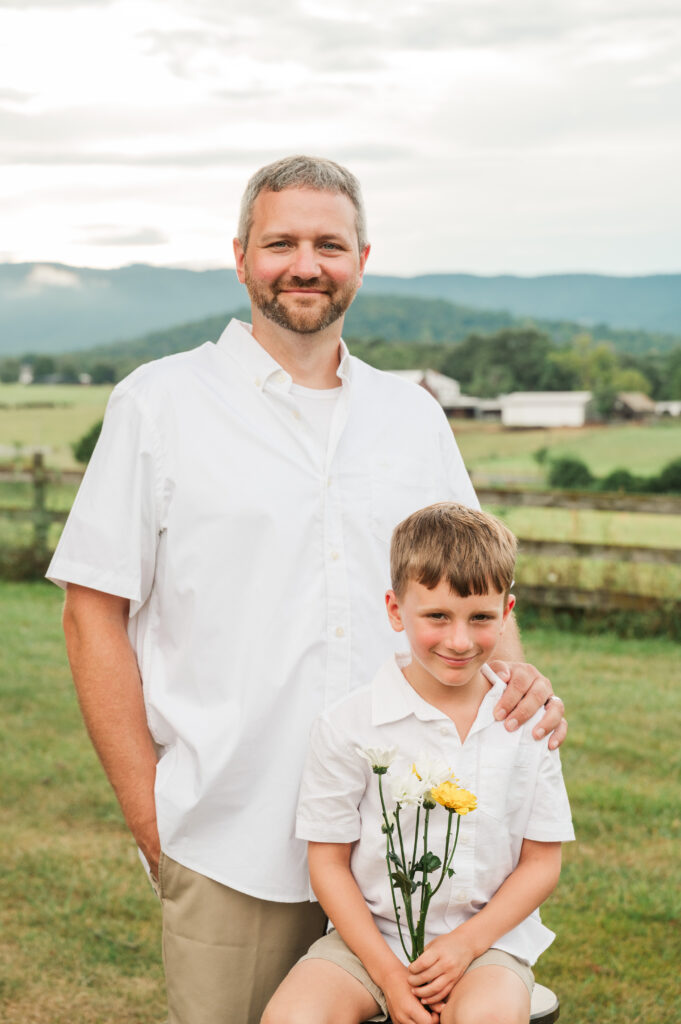 father and son portrait with farm and mountain views