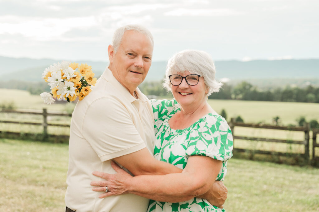 Grandparents holding daisies to celebrate their 50th anniversary at a private estate in Elkton, VAestate