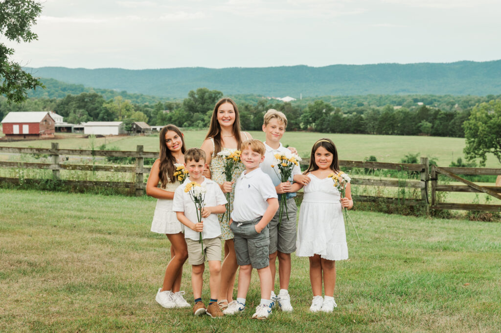portrait of all grandkids with daisies and mountain farm views