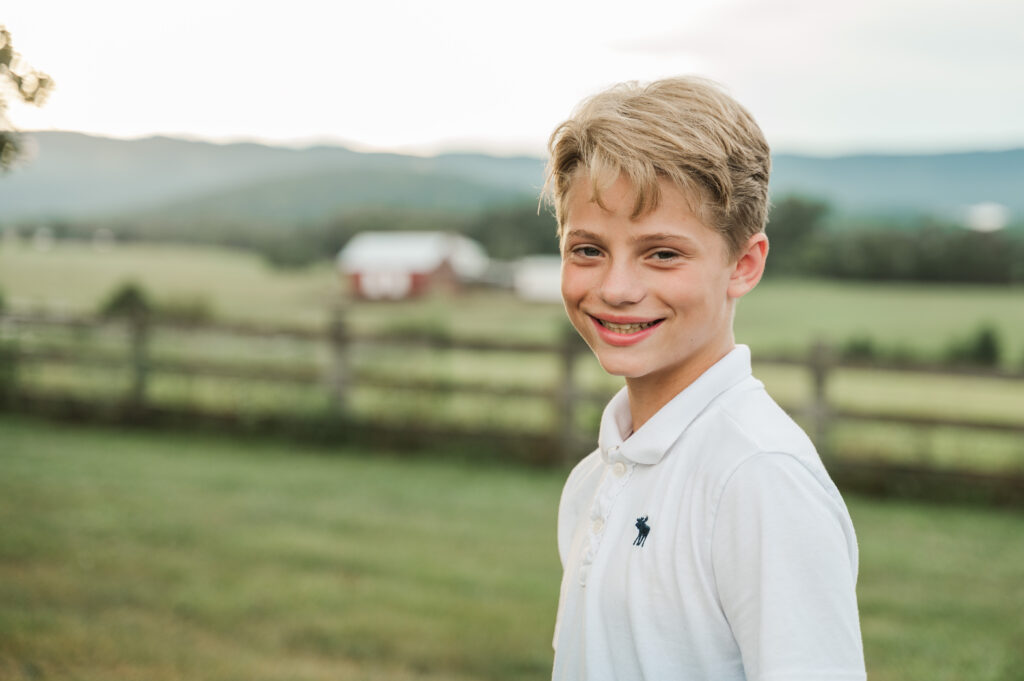 close up of grandson with fenced pasture