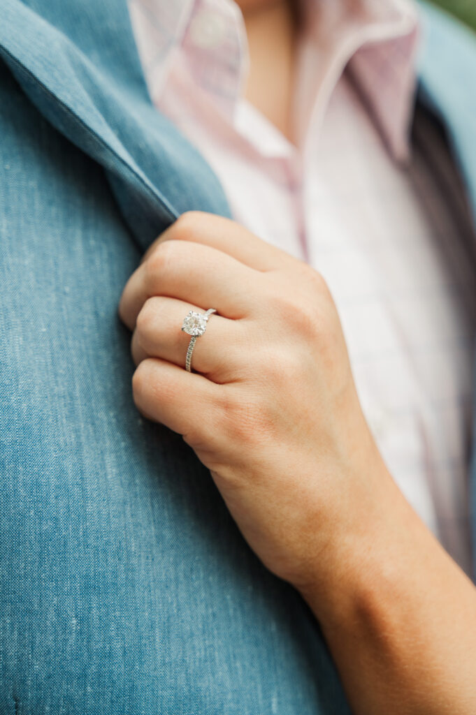 close up of engagement ring on bride to be's finger