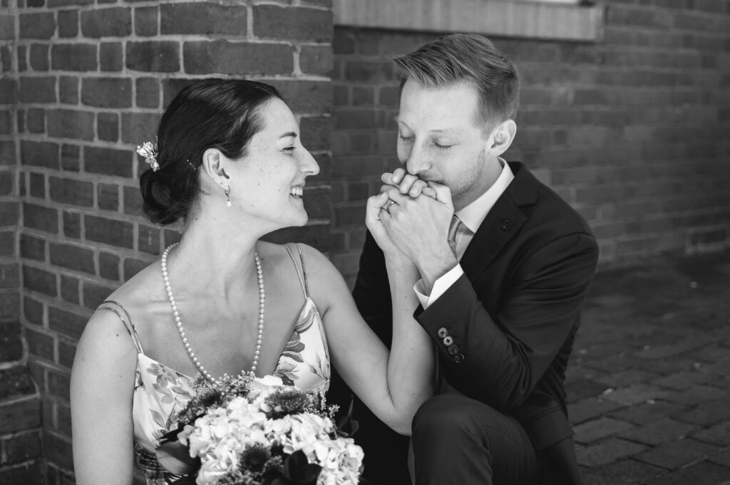 groom kissing bride's hand