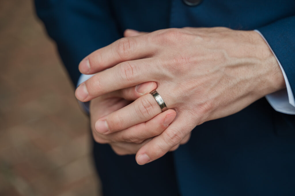 close up of groom's hand with wedding ring