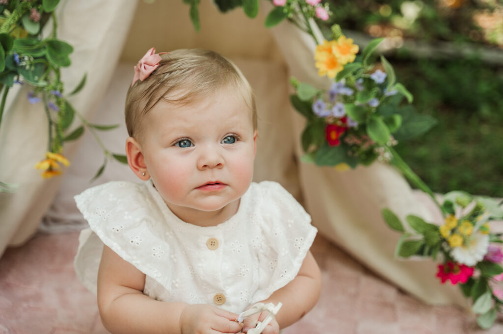 close up of Teagan sitting on blanket with Teepee in the background