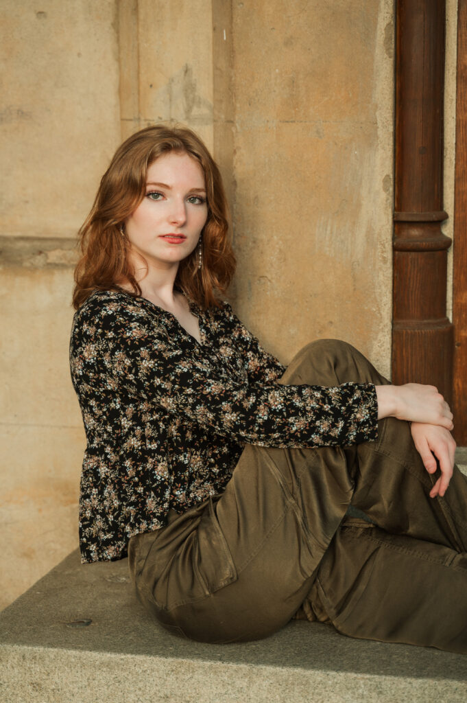 Senior portrait of Raichyl sitting on entrance steps