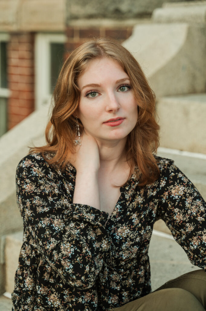 Raichyl with a serious expression sitting on the steps at Caton hall
