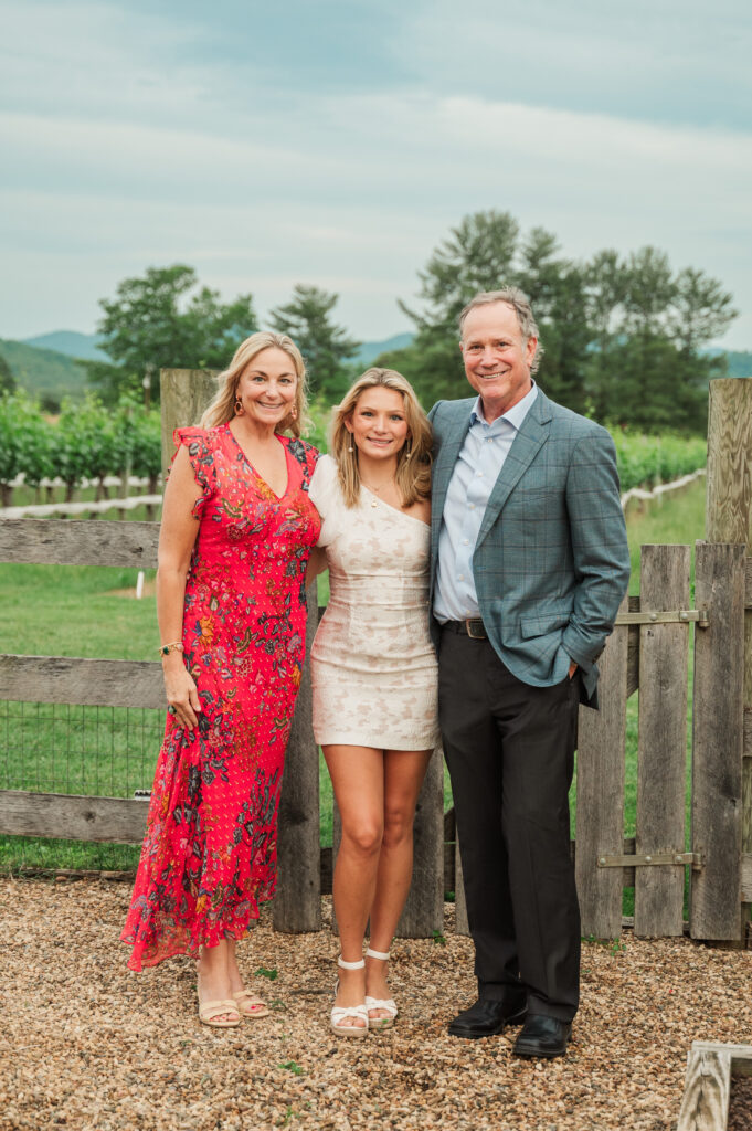 Graduate posing with her parents in garden at Veritas