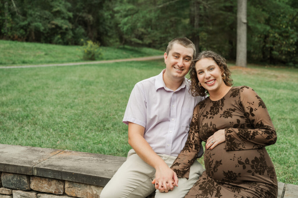 Emily sitting comfortably on rock wall, showing off her fitted dress