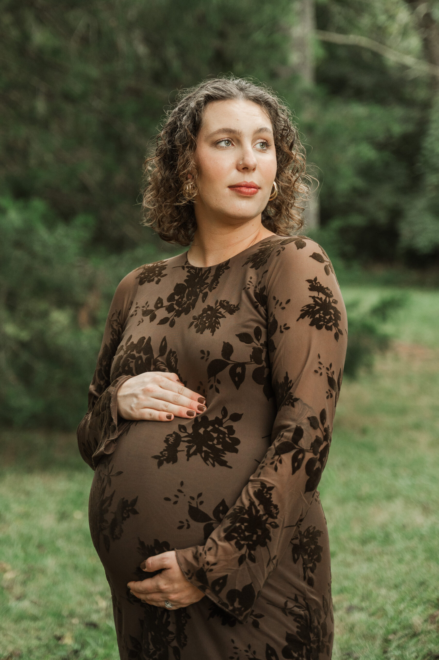 Overcast maternity session on the Saunders-Monticello Trail in Charlottesville, VA, featuring a pregnant woman in a fitted dress