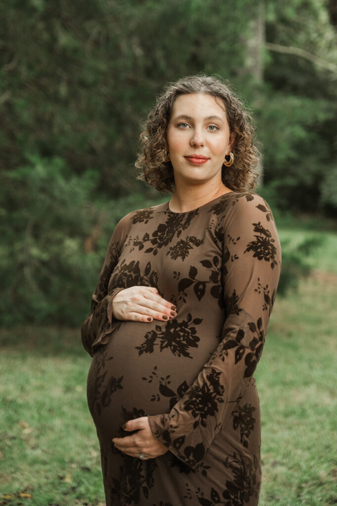 Derek holding a pumpkin against his stomach as a 'mini bump' while he and Emily laugh during their maternity session