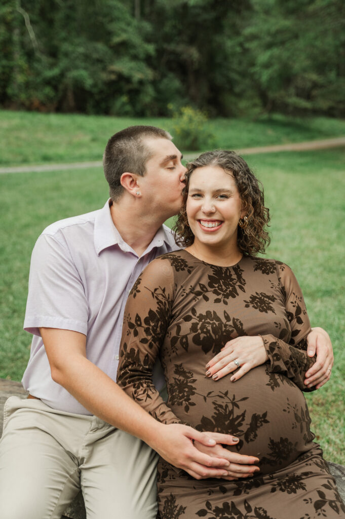 Emily & Derek sitting on the rock wall in park in Albemarle County
