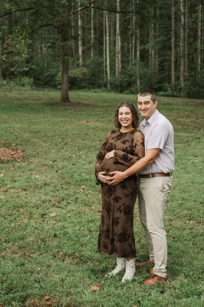 Pregnant Emily wearing a brown fitted maternity dress and stylish white boots during her fall session at Saunders-Monticello Trail with Derek.