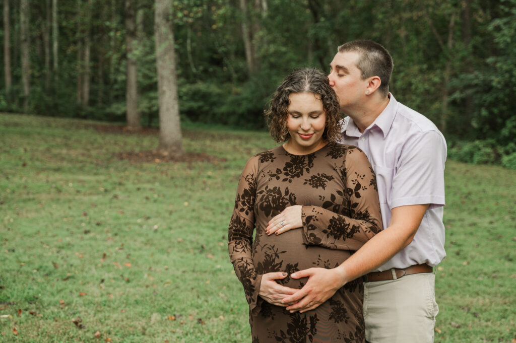 Close-up of Emily's and Derek's hands on Emily's baby bump on the Saunders-Monticello Trail.