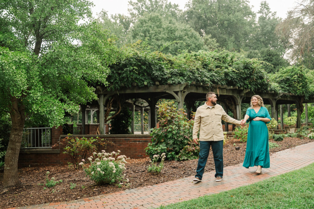maternity couple walking at Tanglewood Park