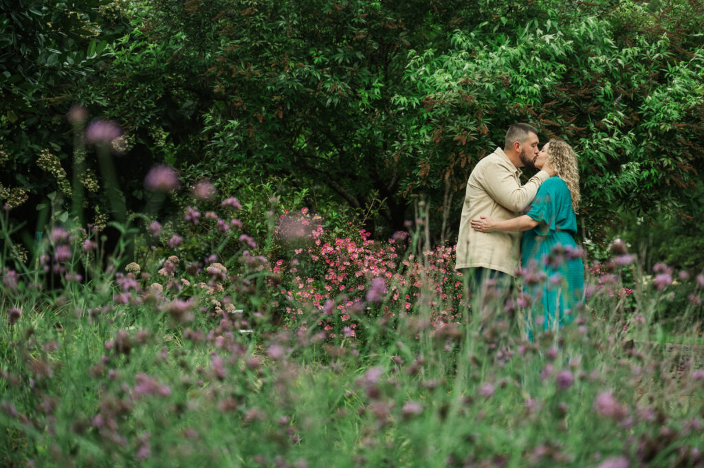 Expecting couple embracing during a break in the rain at a Clemmons NC photo session.