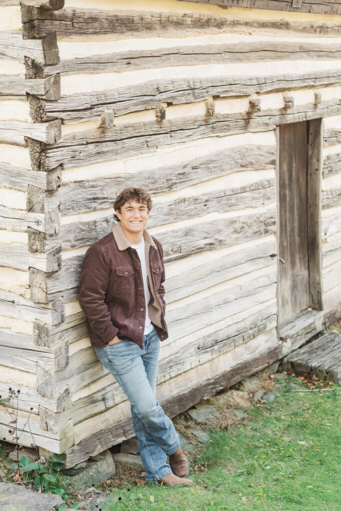 Nicholas leaning again log cabin