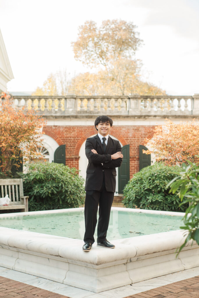 Senior guy standing on fountain at Rotunda in black suit