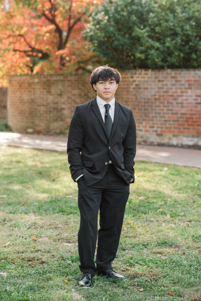 Senior standing by serpentine wall by UVA Chapel