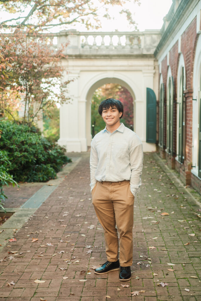 William Monroe High School senior guy standing in front of archway at UVA