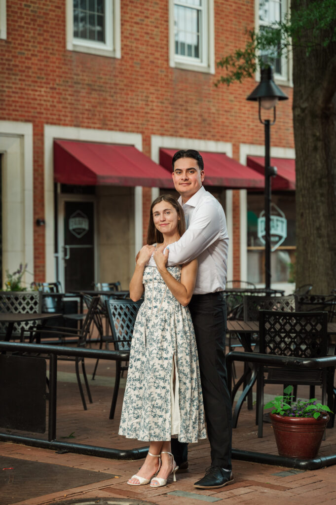 couple standing with Alex's arm around her on Downtown Mall in Charlottesville