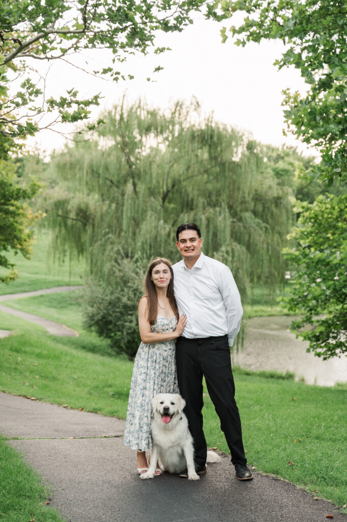 couple standing with Duke at park at Pantops with small pond in background