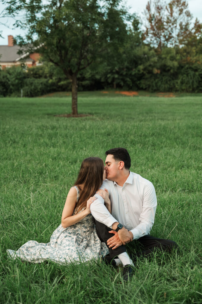 couple sitting in park kissing