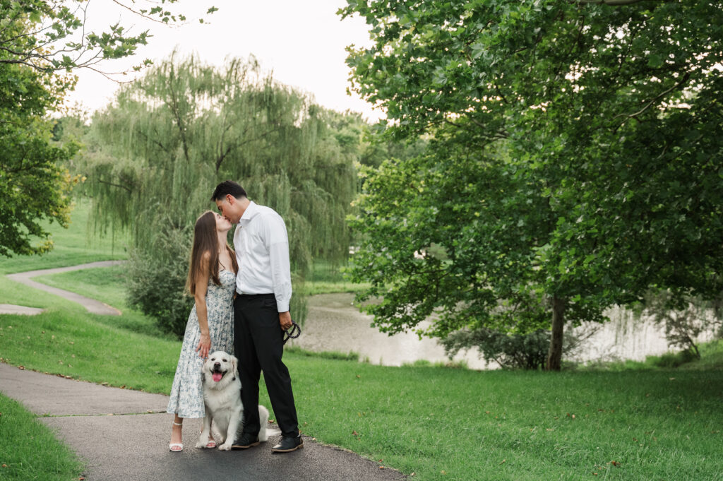 couple kissing while Duke sits between them on path in park at Pantops
