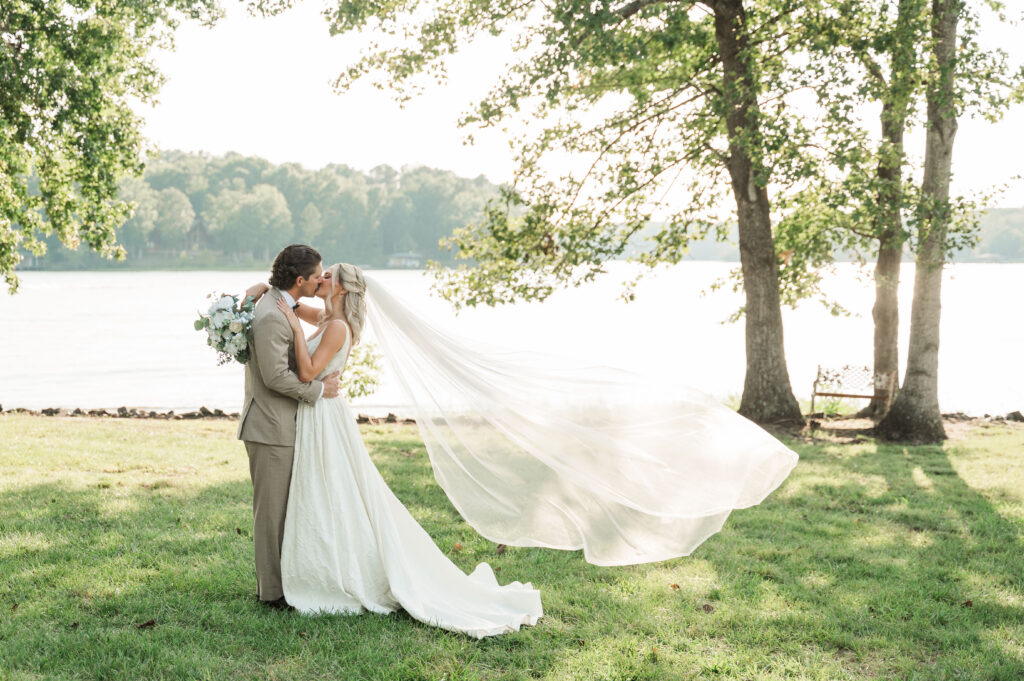 bride and groom lakeside with flying veil