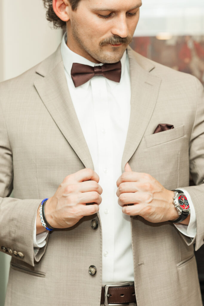 groom holding jacket below the lapel